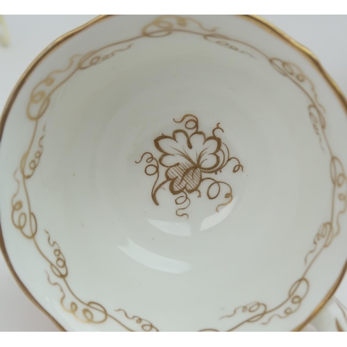 2152 - A ROCKINGHAM STYLE TEASETof moulded rococo design, the white ground with gilt vine and grape decorat... 