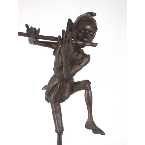 2193 - A LARGE BRONZE OF A PIXIEmodelled standing on one leg playing a pipe, upon circular marble base, 79c... 