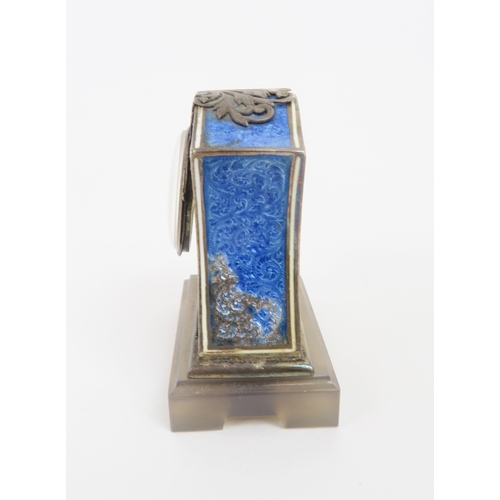 2203 - A FRENCH SILVER AND BLUE BASSE-TAILLE ENAMEL MINIATURE TIMEPIECEupon a carved agate base, ... 