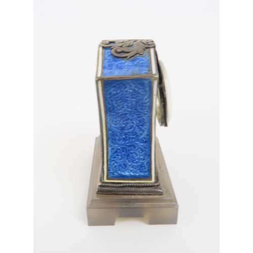 2203 - A FRENCH SILVER AND BLUE BASSE-TAILLE ENAMEL MINIATURE TIMEPIECEupon a carved agate base, ... 