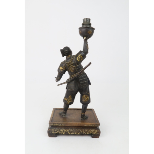 2366 - A JAPANESE BRONZE SAMURAI LAMP Standing and wearing battle dress, decorated with family Mon crests a... 