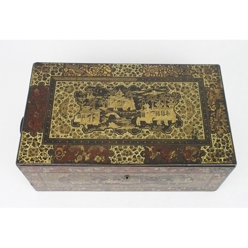 2382 - A CANTON BLACK AND GOLD LAQUERED WRITING SLOPE Decorated with various panels, fitted with velvet ski... 