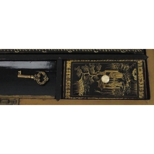 2382 - A CANTON BLACK AND GOLD LAQUERED WRITING SLOPE Decorated with various panels, fitted with velvet ski... 