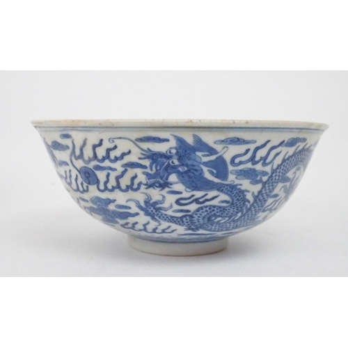 2392 - A CHINESE CELADON GLAZED BOWL Carved with foliage, 19.5cm diameter and a blue and white dragon bowl,... 