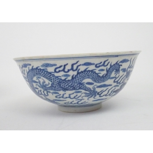 2392 - A CHINESE CELADON GLAZED BOWL Carved with foliage, 19.5cm diameter and a blue and white dragon bowl,... 