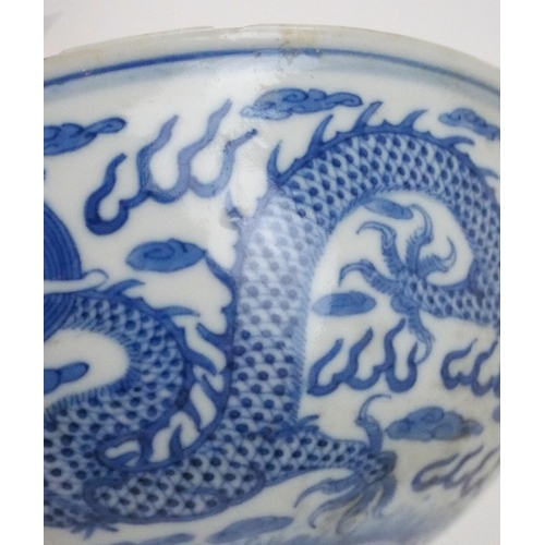 2392 - A CHINESE CELADON GLAZED BOWL Carved with foliage, 19.5cm diameter and a blue and white dragon bowl,... 