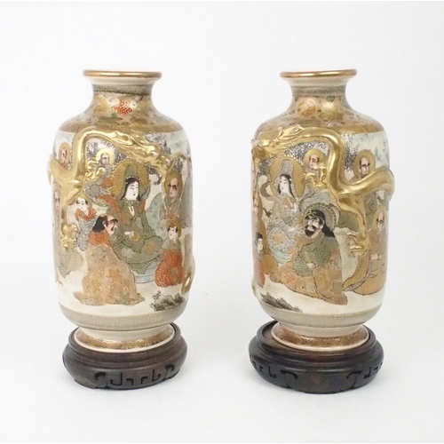 2397 - A PAIR OF SATSUMA VASES Each applied with moulded gilt dragons, enclosing Kannon and Sennin wit... 