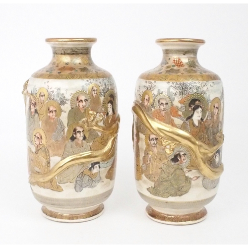 2397 - A PAIR OF SATSUMA VASES Each applied with moulded gilt dragons, enclosing Kannon and Sennin wit... 