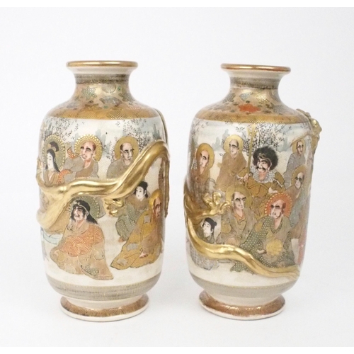 2397 - A PAIR OF SATSUMA VASES Each applied with moulded gilt dragons, enclosing Kannon and Sennin wit... 