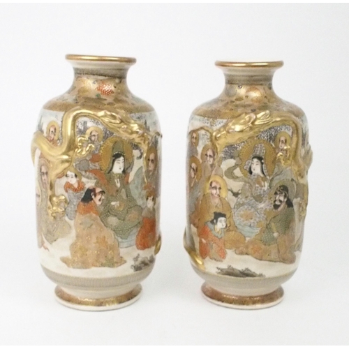 2397 - A PAIR OF SATSUMA VASES Each applied with moulded gilt dragons, enclosing Kannon and Sennin wit... 