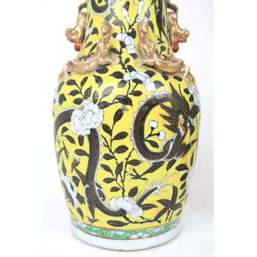 2399 - A PAIR OF CHINESE YELLOW GROUND VASES Each applied with gilt dragons and shishi, amongst scroll... 