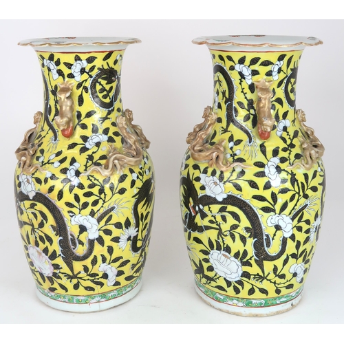 2399 - A PAIR OF CHINESE YELLOW GROUND VASES Each applied with gilt dragons and shishi, amongst scroll... 