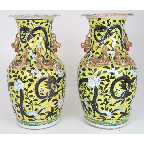 2399 - A PAIR OF CHINESE YELLOW GROUND VASES Each applied with gilt dragons and shishi, amongst scroll... 