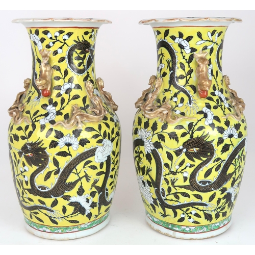 2399 - A PAIR OF CHINESE YELLOW GROUND VASES Each applied with gilt dragons and shishi, amongst scroll... 