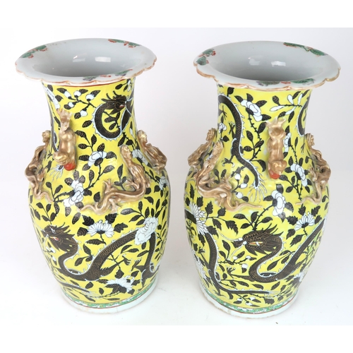 2399 - A PAIR OF CHINESE YELLOW GROUND VASES Each applied with gilt dragons and shishi, amongst scroll... 