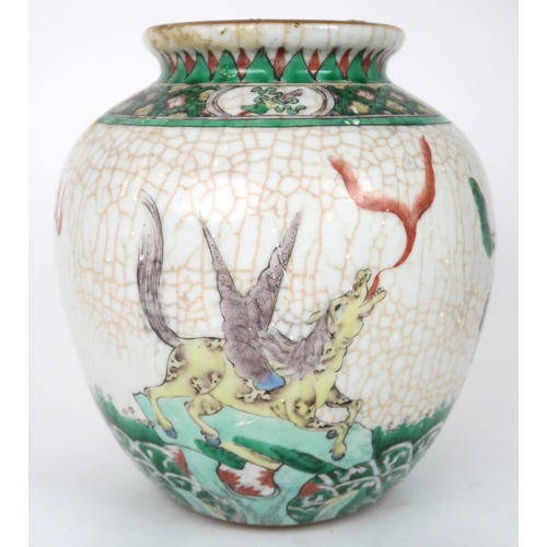 2400 -  A CHINESE FAMILLE VERTE JAR Painted with winged shishi on a crackled ground and bene... 