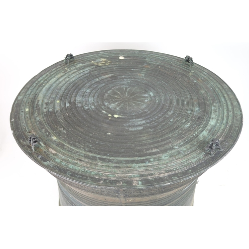 2409 - A LAOTIAN BRONZE RAIN DRUM Of traditional type, with applied animals to top and pierced strap h... 