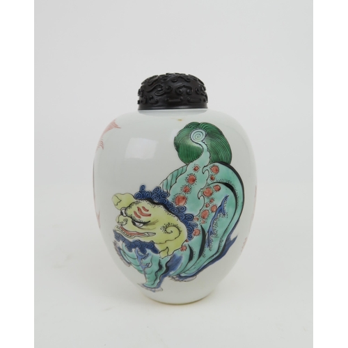 2421 - A CHINESE PORCELAIN OVIFORM VASE Painted with three shishi, carved hardwood cover, 15cm high... 