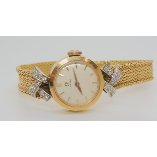 2893A - AN 18CT GOLD DIAMOND SET LADIES OMEGA with cream coloured dial, gold coloured baton numeral and... 