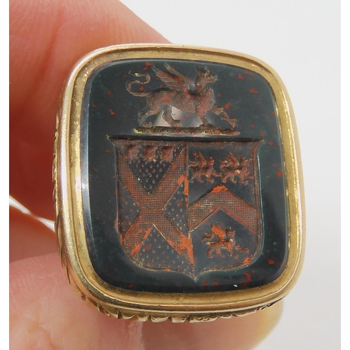 2715 - A DECORATIVE YELLOW METAL FOB SEALthe bloodstone face intaglio carved, with a griffin and family cre... 