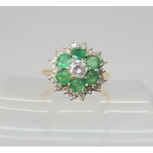 2719 - A DIAMOND AND EMERALD CLUSTER RINGmounted throughout in 18ct gold, the central brilliant cut  d... 