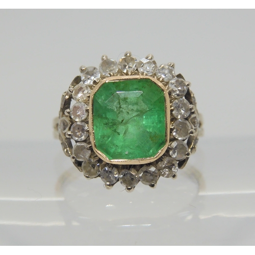 2724 - AN EMERALD AND DIAMOND RINGset throughout in yellow and white metal with diamond set fleur de lys sh... 