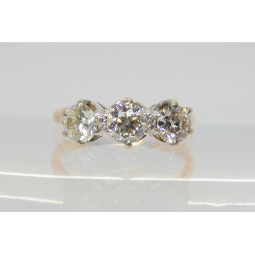 2729 - A THREE STONE DIAMOND RINGwith traditional yellow and white metal mount, set with estimated approx 0... 