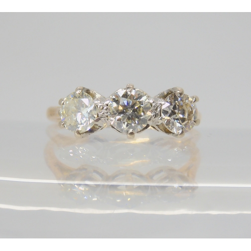 2729 - A THREE STONE DIAMOND RINGwith traditional yellow and white metal mount, set with estimated approx 0... 