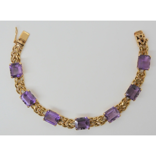 2747 - A FANCY LINK AMETHYST BRACELETthe box clasp stamped 18k, and set with seven step cut amethysts with ... 