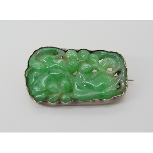 2748 - A CHINESE GREEN HARDSTONE BROOCHcarved with a fruiting plant, in a white metal brooch mount. Dimensi... 