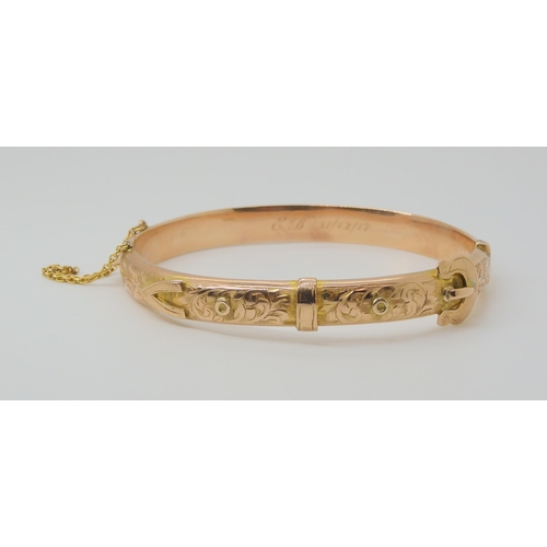 2772 - A 9CT ROSE GOLD BUCKLE SHAPED BANGLEwith floral engraving, hallmarked Birmingham 1916, with inscript... 