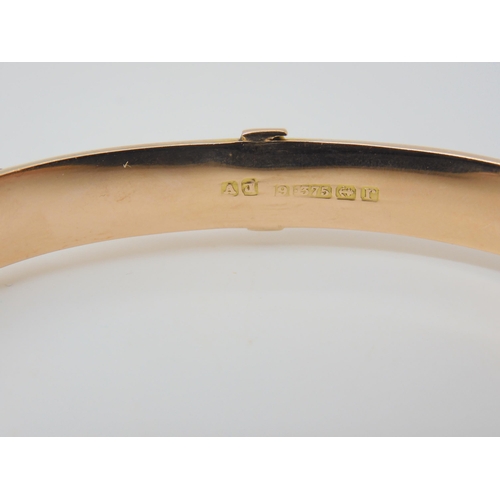 2772 - A 9CT ROSE GOLD BUCKLE SHAPED BANGLEwith floral engraving, hallmarked Birmingham 1916, with inscript... 