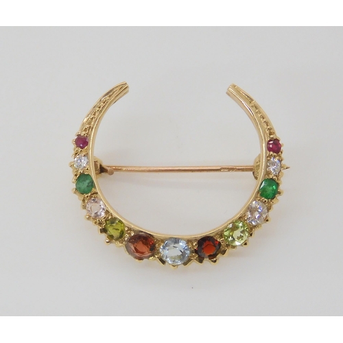 2781 - A CRESENT MOON BROOCHset with gemstones to include rubies, peridot and emerald, diameter 2.6cm, weig... 