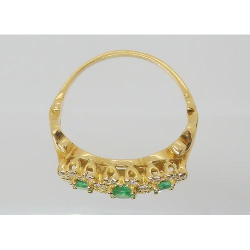 2788 - AN EMERALD & DIAMOND FLOWER CLUSTER RINGset with three emeralds, the largest approx 3.6mm, surro... 