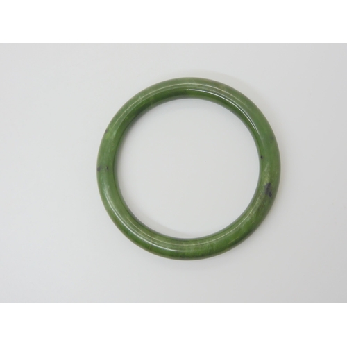 2792 - A CHINESE GREEN HARSTONE BANGLEinner diameter 6.2cm, thickness approx 9mm, weight 41.2gms... 