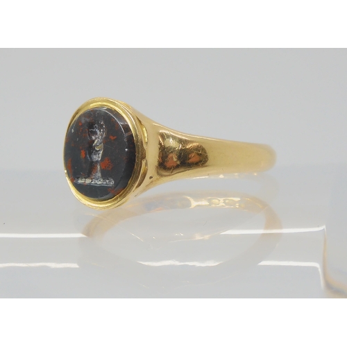 2794 - AN 18CT GOLD INTAGLIO SIGNET RINGset with an intaglio carved bloodstone, depicting a hand holding a ... 