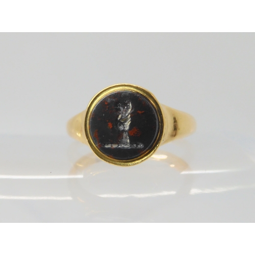 2794 - AN 18CT GOLD INTAGLIO SIGNET RINGset with an intaglio carved bloodstone, depicting a hand holding a ... 