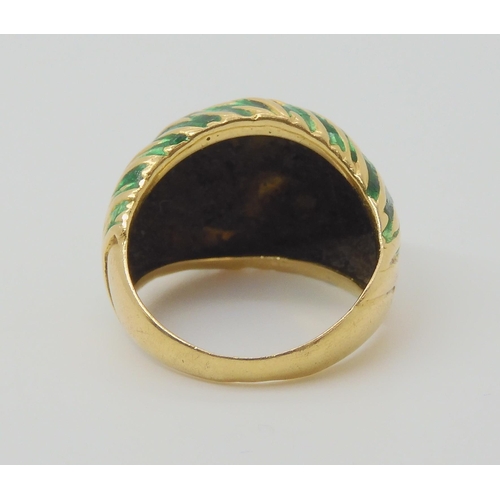 2796 - A KUTCHINSKY ENAMEL RINGthe 18ct yellow gold high domed ring is enamelled in green to the textured g... 