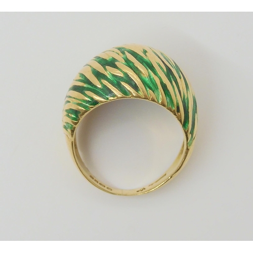 2796 - A KUTCHINSKY ENAMEL RINGthe 18ct yellow gold high domed ring is enamelled in green to the textured g... 