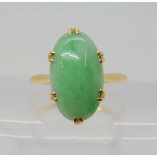 2818 - A CHINESE GREEN HARDSTONE RINGmounted in bright yellow metal, the hardstone measures approx 16mm x 9... 