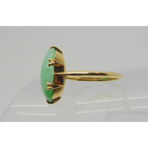 2818 - A CHINESE GREEN HARDSTONE RINGmounted in bright yellow metal, the hardstone measures approx 16mm x 9... 