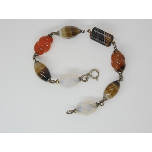 2840 - A CARVED SCOTTISH AGATE BRACELETwith some barley twist carved links, mounted in white metal. Length ... 