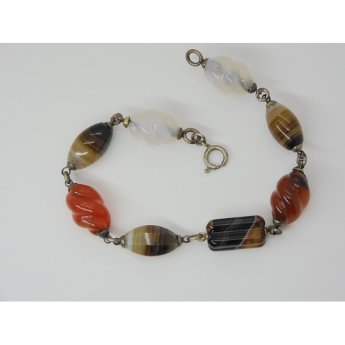 2840 - A CARVED SCOTTISH AGATE BRACELETwith some barley twist carved links, mounted in white metal. Length ... 