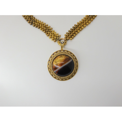 2842 - A VICTORIAN AGATE PENDANTcraftsman made in yellow metal mounted with a banded agate, with blue and w... 