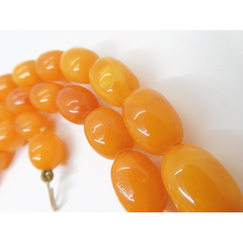 2843 - A STRING OF AMBER BEADSlargest bead 18mm x 12.4mm, smallest 13.3mm x 9.4mm, overall length 79cm, wei... 