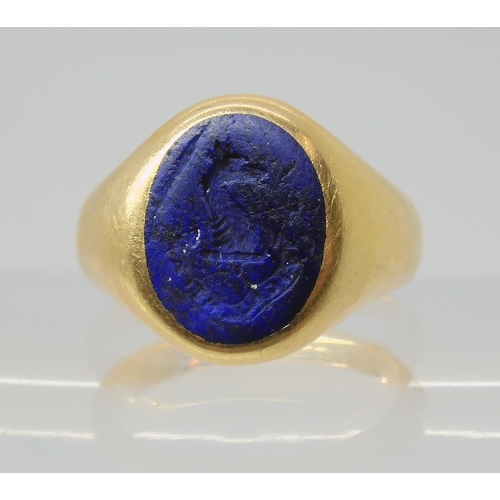 2849 - AN ITAGLIO SIGNET RINGset with a carved lapis lazuli, with Motto & Crest, 'watch over me'. Finge... 