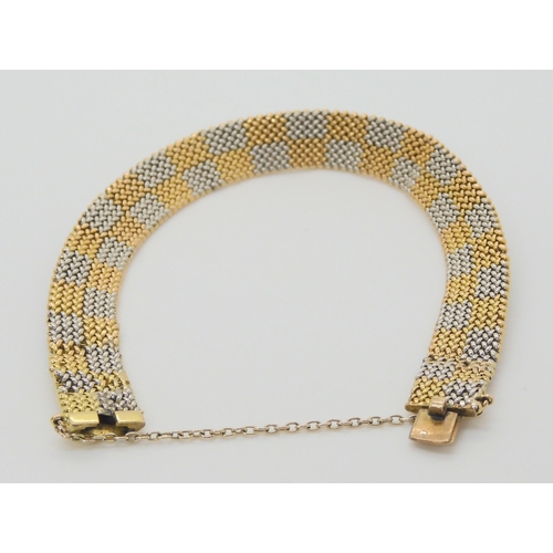 2864 - A CHEQUER BOARD PATTERN BRACELETmanufactured in yellow and white metal with a box clasp, length 19cm... 