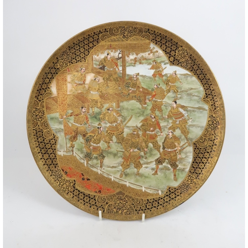 2426 - A SATSUMA DISH Painted with Samurai  warriors in training beside a pavillion, and within cell patter... 