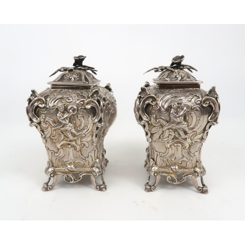 2497 - A PAIR OF WILLIAM IV SILVER CHINOSERIE TEA CADDIESof bombe form, profusely chased with rococo scroll... 