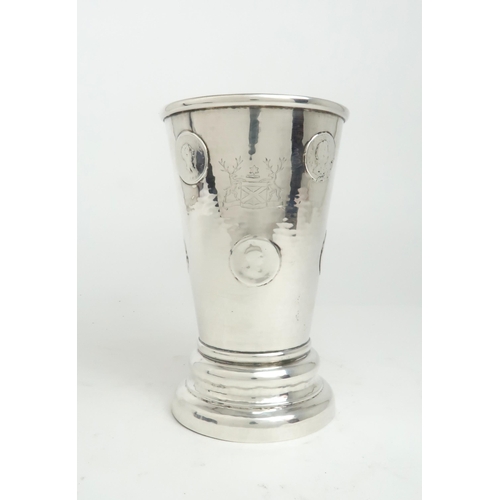 2499 - A WHITE METAL TAVERN BEAKER of flaring cylindrical form, the body engraved with a crest featuring a ... 